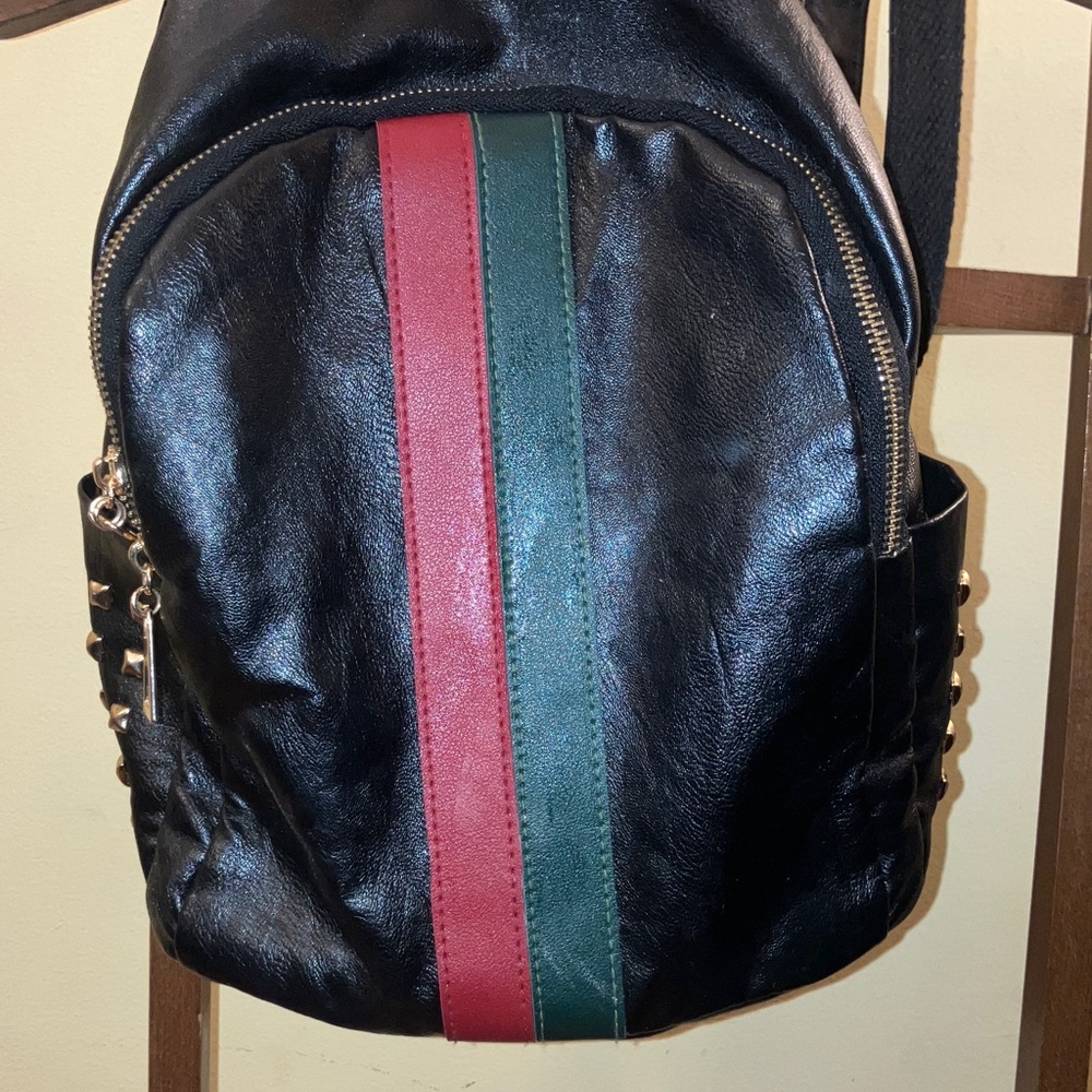 Black back pack with green and red stripe and embellishments